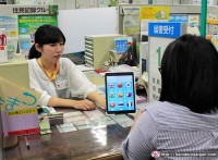 Một nhân viên tại chính quyền thành phố Hamamatsu ở tỉnh Shizuoka cho thấy các dịch vụ phiên dịch trên máy tính bảng để trả lời một cư dân nước ngoài